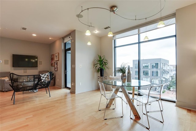 301 NE 4th St Unit 10, Oklahoma City, OK 73104 - dining room with floor to ceiling windows and light wood finished floors