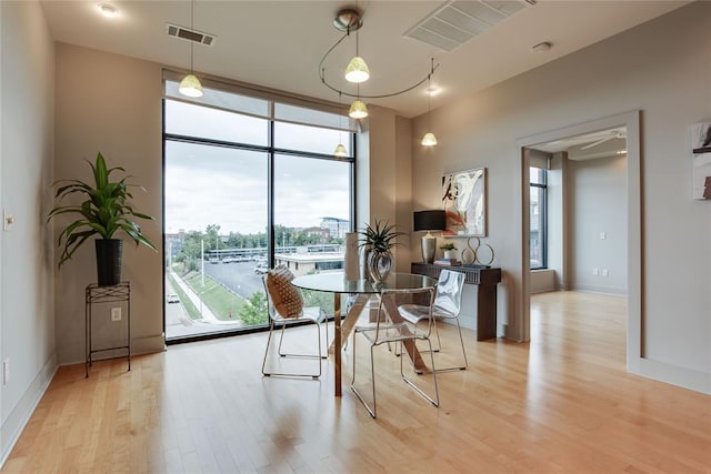 301 NE 4th St Unit 10, Oklahoma City, OK 73104 - dining area with light wood-style flooring, floor to ceiling windows, and baseboards