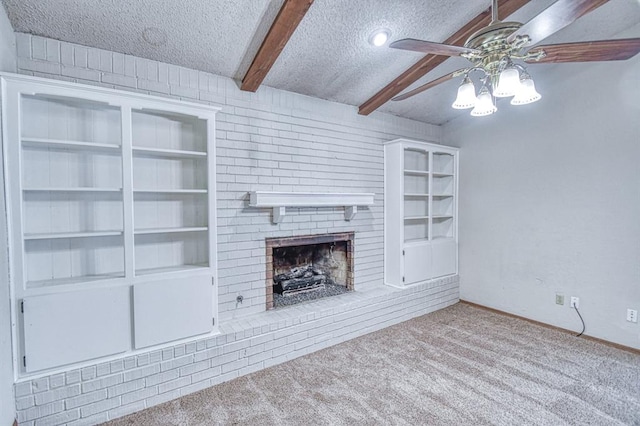 2804 Meadow Ave, Norman, OK 73072 - unfurnished living room with ceiling fan, a textured ceiling, beam ceiling, carpet floors, and a brick fireplace