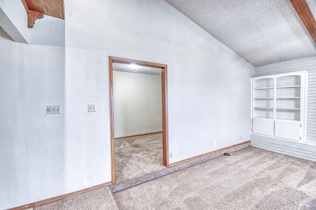 2804 Meadow Ave, Norman, OK 73072 - empty room featuring carpet, a textured ceiling, a textured wall, and vaulted ceiling