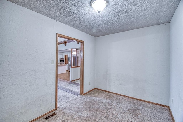 2804 Meadow Ave, Norman, OK 73072 - unfurnished room featuring carpet, a textured wall, a textured ceiling, and baseboards
