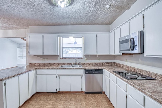 2804 Meadow Ave, Norman, OK 73072 - kitchen with appliances with stainless steel finishes, a sink, a textured ceiling, white cabinetry, and light flooring
