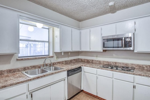2804 Meadow Ave, Norman, OK 73072 - kitchen featuring appliances with stainless steel finishes, a sink, white cabinetry, and a textured ceiling