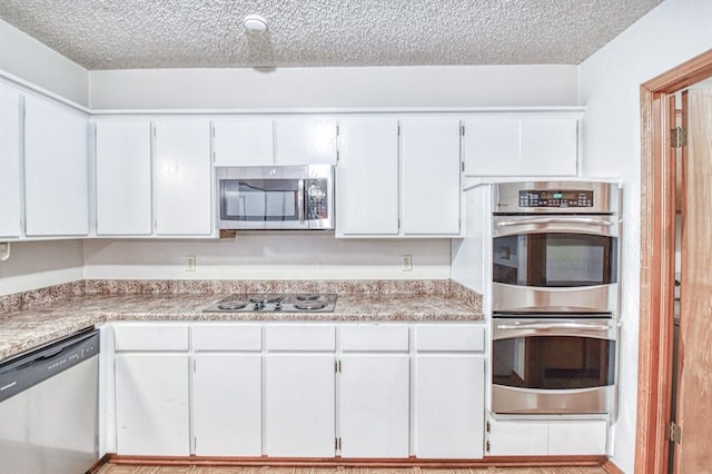 2804 Meadow Ave, Norman, OK 73072 - kitchen with stainless steel appliances, a textured ceiling, light countertops, and white cabinetry