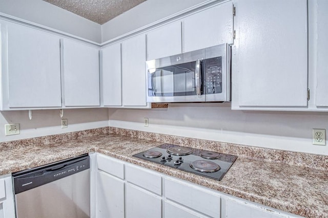 2804 Meadow Ave, Norman, OK 73072 - kitchen featuring appliances with stainless steel finishes, light countertops, white cabinetry, and a textured ceiling