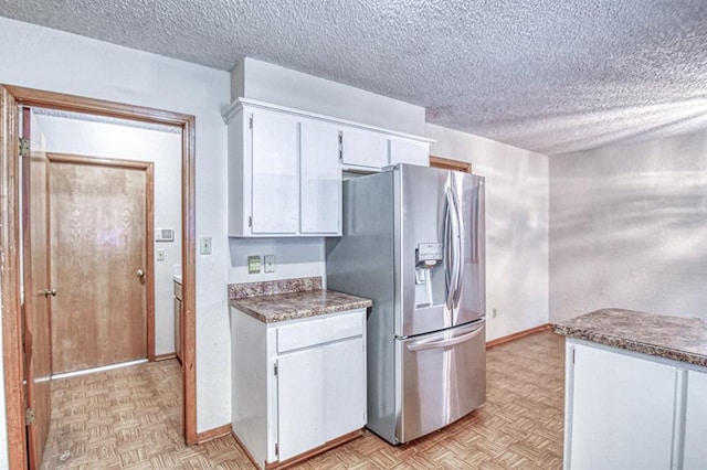 2804 Meadow Ave, Norman, OK 73072 - kitchen with stainless steel fridge with ice dispenser, white cabinets, a textured ceiling, and baseboards