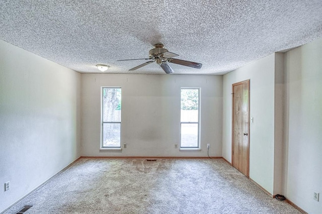 2804 Meadow Ave, Norman, OK 73072 - unfurnished room featuring plenty of natural light, carpet, ceiling fan, and a textured ceiling