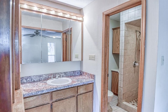 2804 Meadow Ave, Norman, OK 73072 - bathroom featuring toilet, a tile shower, vanity, ceiling fan, and tile patterned flooring