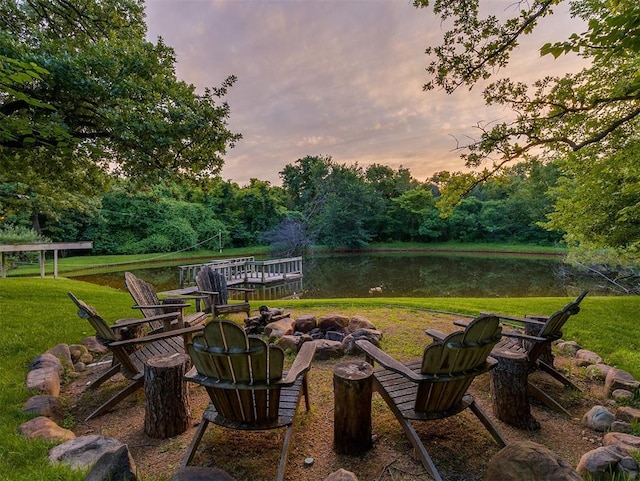 4005 NE 122nd St, Edmond, OK 73013 - yard at dusk with a fire pit, a water view, a yard, and a view of trees