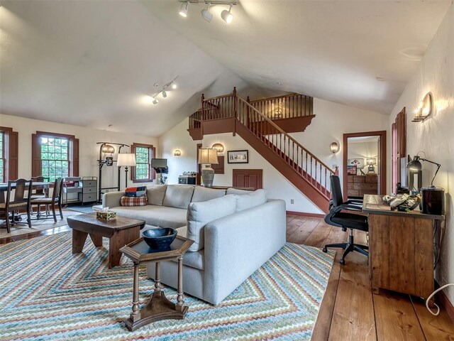 4005 NE 122nd St, Edmond, OK 73013 - living area with rail lighting, vaulted ceiling, hardwood / wood-style floors, and stairway