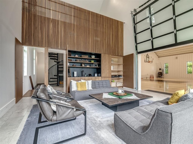 4005 NE 122nd St, Edmond, OK 73013 - living room featuring a towering ceiling, stairs, and wooden walls