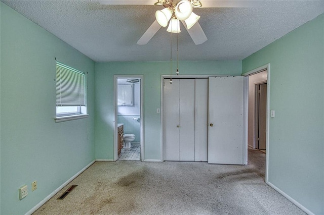 342 W Birch Dr, Mustang, OK 73064 - unfurnished bedroom featuring carpet flooring, a textured ceiling, a closet, connected bathroom, and a ceiling fan