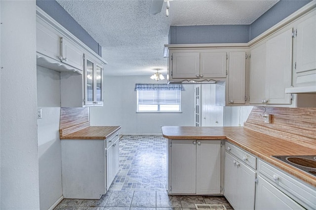 342 W Birch Dr, Mustang, OK 73064 - kitchen featuring a textured ceiling, a peninsula, white cabinets, and ceiling fan
