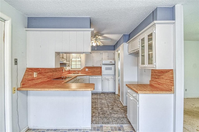 342 W Birch Dr, Mustang, OK 73064 - kitchen with white appliances, a peninsula, a ceiling fan, light countertops, and under cabinet range hood