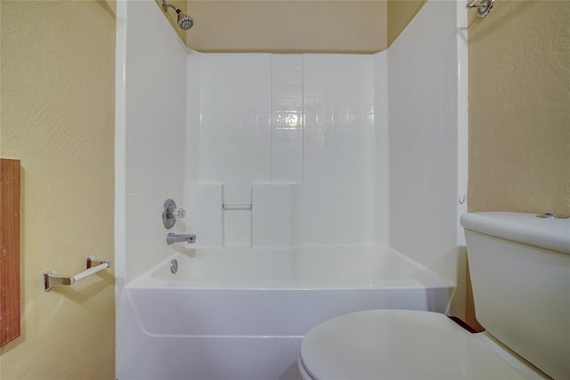 913 Elm Creek Dr, Moore, OK 73160 - bathroom featuring toilet, a textured wall, and washtub / shower combination