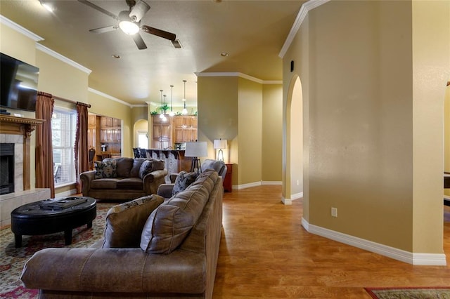 262 Shrouder Rd, Broken Bow, OK 74728 - living area with arched walkways, a ceiling fan, crown molding, baseboards, and wood finished floors