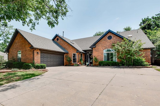 1408 Carlton, Edmond, OK 73034 - view of front of property featuring brick siding, a shingled roof, a garage, and concrete driveway