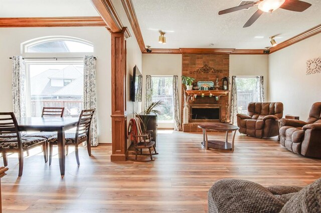 1408 Carlton, Edmond, OK 73034 - living area with healthy amount of natural light, crown molding, light wood finished floors, a ceiling fan, and a large fireplace