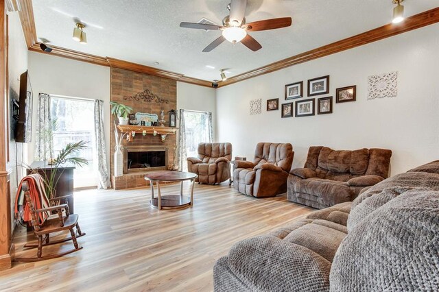 1408 Carlton, Edmond, OK 73034 - living room with wood finished floors, crown molding, a ceiling fan, a brick fireplace, and a textured ceiling
