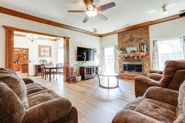1408 Carlton, Edmond, OK 73034 - living room with plenty of natural light, a ceiling fan, light wood-type flooring, ornamental molding, and a fireplace