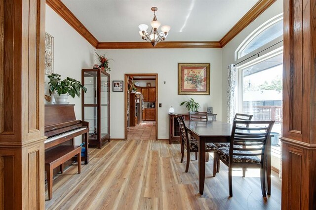 1408 Carlton, Edmond, OK 73034 - dining room with a chandelier, crown molding, light wood finished floors, and baseboards
