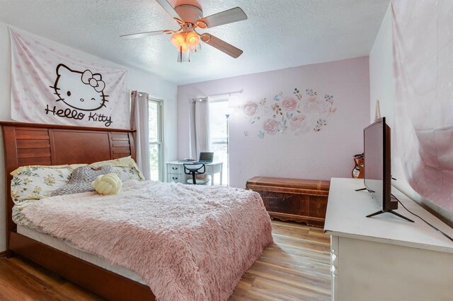 1408 Carlton, Edmond, OK 73034 - bedroom featuring light wood-style floors, a textured ceiling, and a ceiling fan