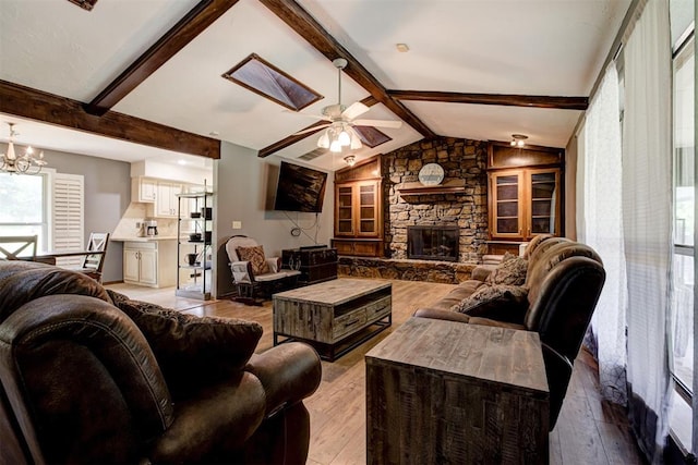11129 E Thayer St, Midwest City, OK 73130 - living room featuring hardwood / wood-style flooring, a stone fireplace, a ceiling fan, and a chandelier