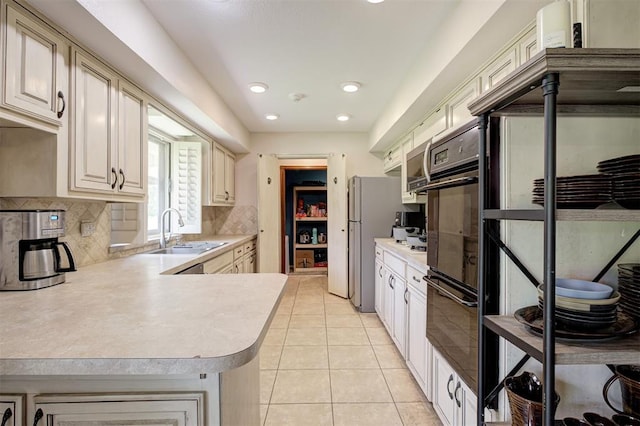 11129 E Thayer St, Midwest City, OK 73130 - kitchen with light countertops, decorative backsplash, light tile patterned floors, recessed lighting, and a peninsula