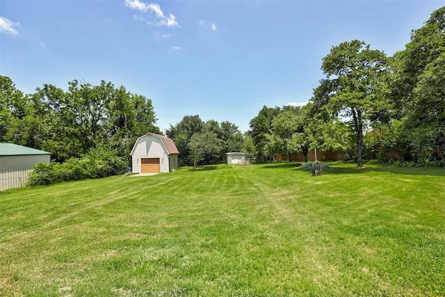 11129 E Thayer St, Midwest City, OK 73130 - view of grassy yard featuring a storage unit, a detached garage, and view of wooded area