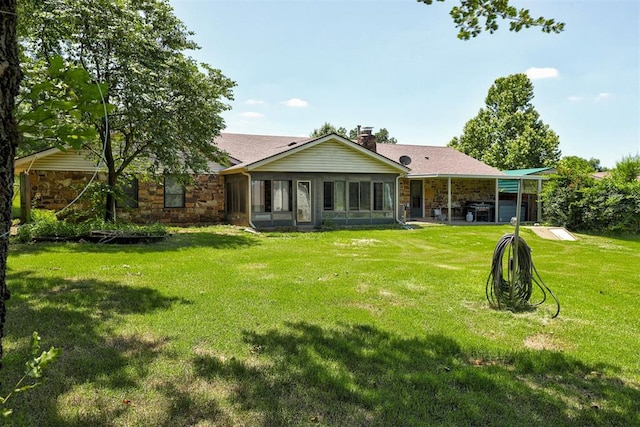 11129 E Thayer St, Midwest City, OK 73130 - rear view of property with stone siding, a chimney, a lawn, and a sunroom