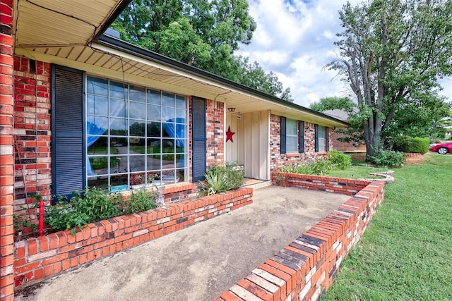 801 Bonnie Ave, Purcell, OK 73080 - view of front of home with brick siding, a front yard, and board and batten siding