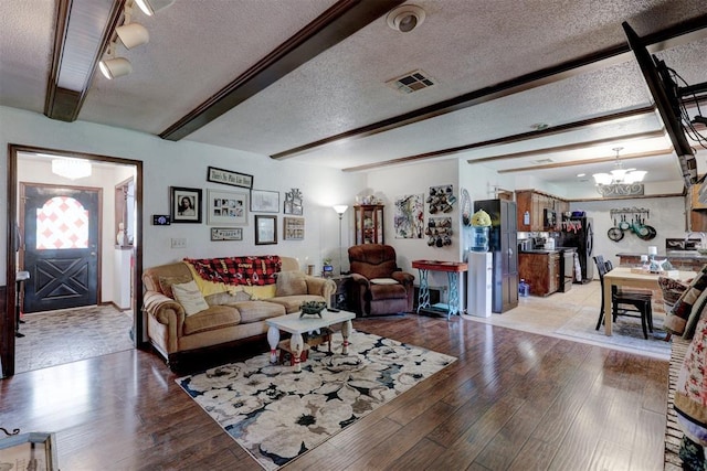 801 Bonnie Ave, Purcell, OK 73080 - living area with a chandelier, light wood-style flooring, a textured ceiling, and beam ceiling