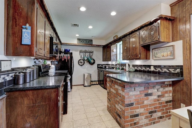 801 Bonnie Ave, Purcell, OK 73080 - kitchen featuring dark countertops, black appliances, a sink, a peninsula, and recessed lighting