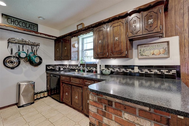 801 Bonnie Ave, Purcell, OK 73080 - kitchen featuring dishwasher, a sink, dark countertops, dark brown cabinets, and backsplash