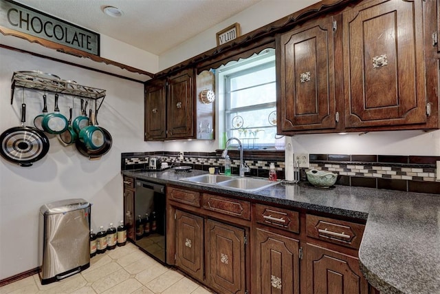 801 Bonnie Ave, Purcell, OK 73080 - kitchen with black dishwasher, a sink, decorative backsplash, dark countertops, and dark brown cabinetry