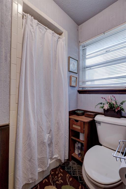 801 Bonnie Ave, Purcell, OK 73080 - bathroom with toilet, a textured ceiling, and a shower with curtain
