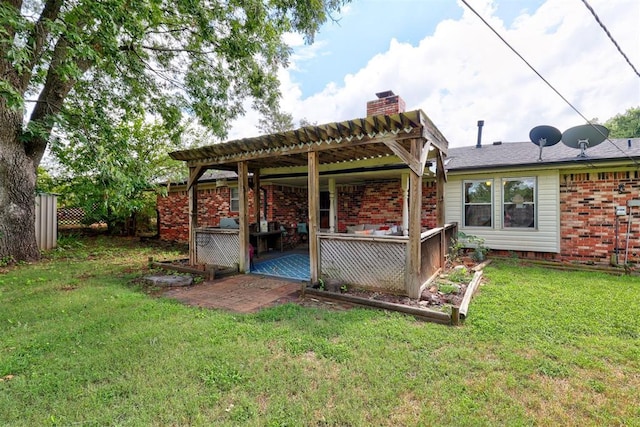 801 Bonnie Ave, Purcell, OK 73080 - back of house featuring a chimney, a lawn, a patio, outdoor lounge area, and brick siding