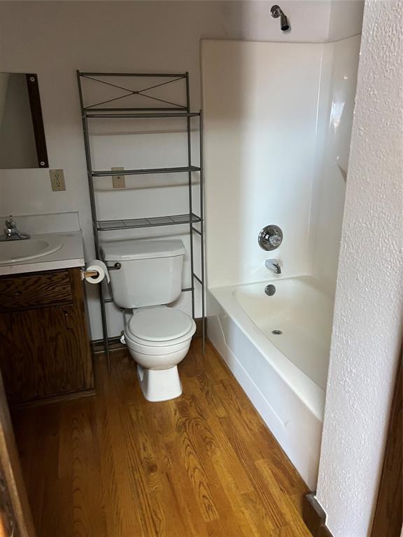 802 N Hudson St, Altus, OK 73521 - full bath with vanity, wood finished floors, and tub / shower combination