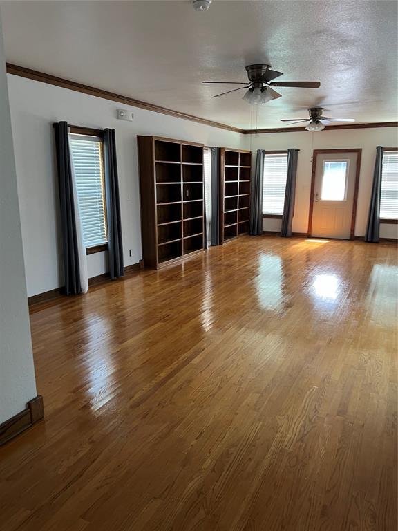 802 N Hudson St, Altus, OK 73521 - spare room with ceiling fan, wood finished floors, crown molding, and a smoke detector