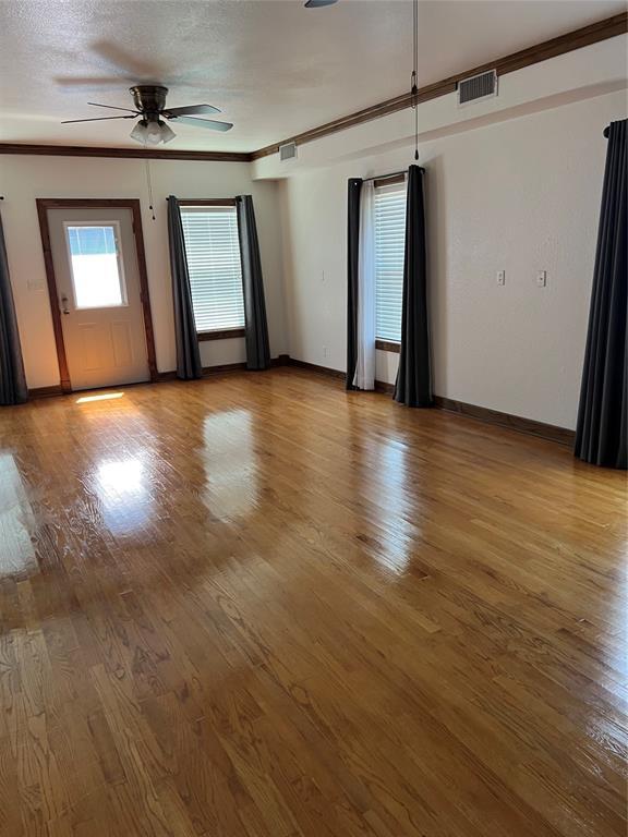 802 N Hudson St, Altus, OK 73521 - unfurnished room with ceiling fan, light wood-type flooring, and ornamental molding