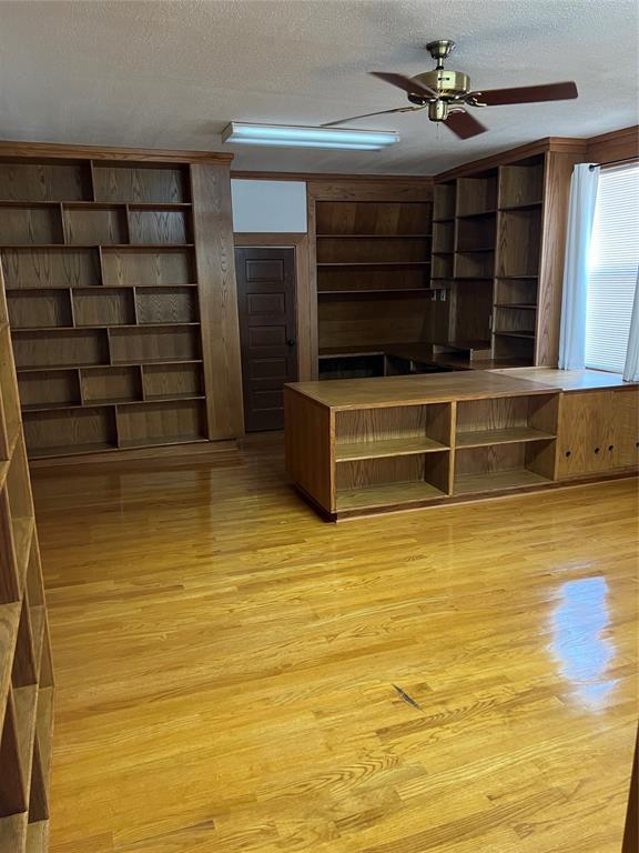 802 N Hudson St, Altus, OK 73521 - unfurnished living room with light wood-style flooring, a textured ceiling, and a ceiling fan
