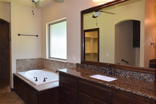 1713 Rain Tree Ln, Midwest City, OK 73130 - bathroom with ceiling fan, a bath, vanity, and a walk in closet