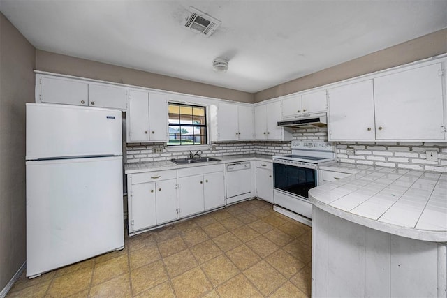 814 NW 48th St, Lawton, OK 73505 - kitchen with white appliances, under cabinet range hood, white cabinets, backsplash, and a sink