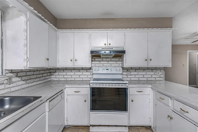 814 NW 48th St, Lawton, OK 73505 - kitchen with under cabinet range hood, white appliances, tasteful backsplash, light countertops, and white cabinetry