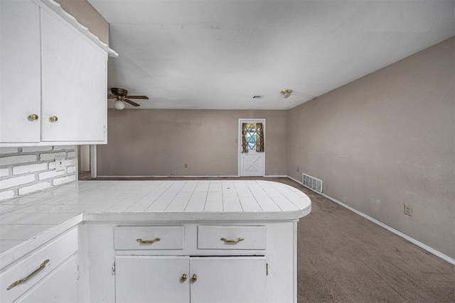814 NW 48th St, Lawton, OK 73505 - kitchen featuring tile countertops, a peninsula, white cabinetry, a ceiling fan, and baseboards