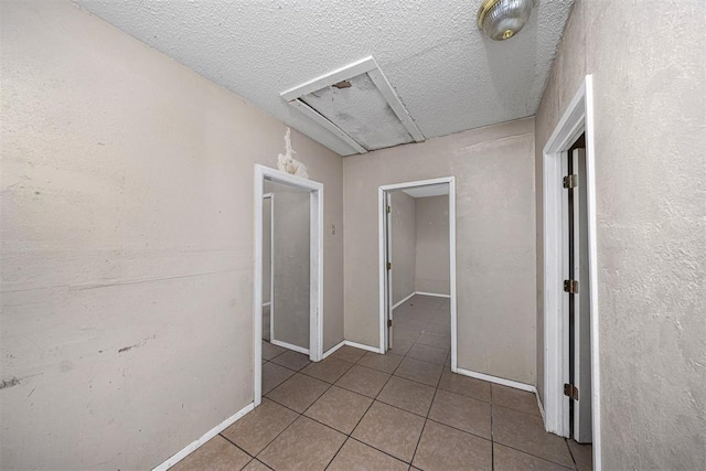 814 NW 48th St, Lawton, OK 73505 - corridor with tile patterned floors, a textured ceiling, and baseboards