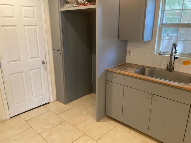707 W Texas Ave, Anadarko, OK 73005 - kitchen with a sink, gray cabinetry, backsplash, and light tile patterned floors