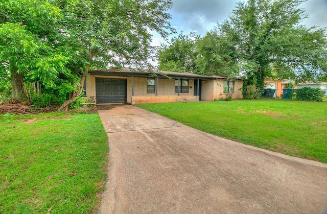 824 E Rose Dr, Midwest City, OK 73110 - view of front of property featuring concrete driveway, a garage, brick siding, and a front lawn