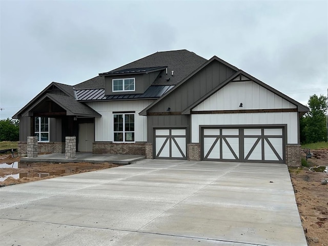 10165 NW 100th St, Yukon, OK 73099 - view of front of property featuring a shingled roof, an attached garage, board and batten siding, and concrete driveway