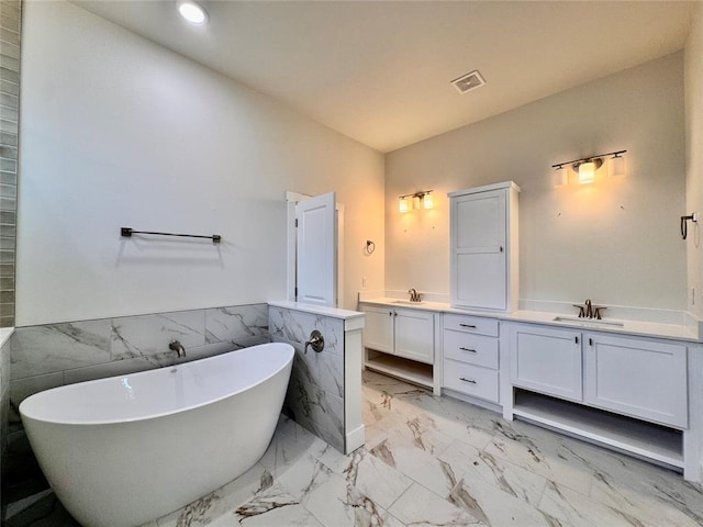 10165 NW 100th St, Yukon, OK 73099 - bathroom with vanity, a soaking tub, marble finish flooring, recessed lighting, and wainscoting